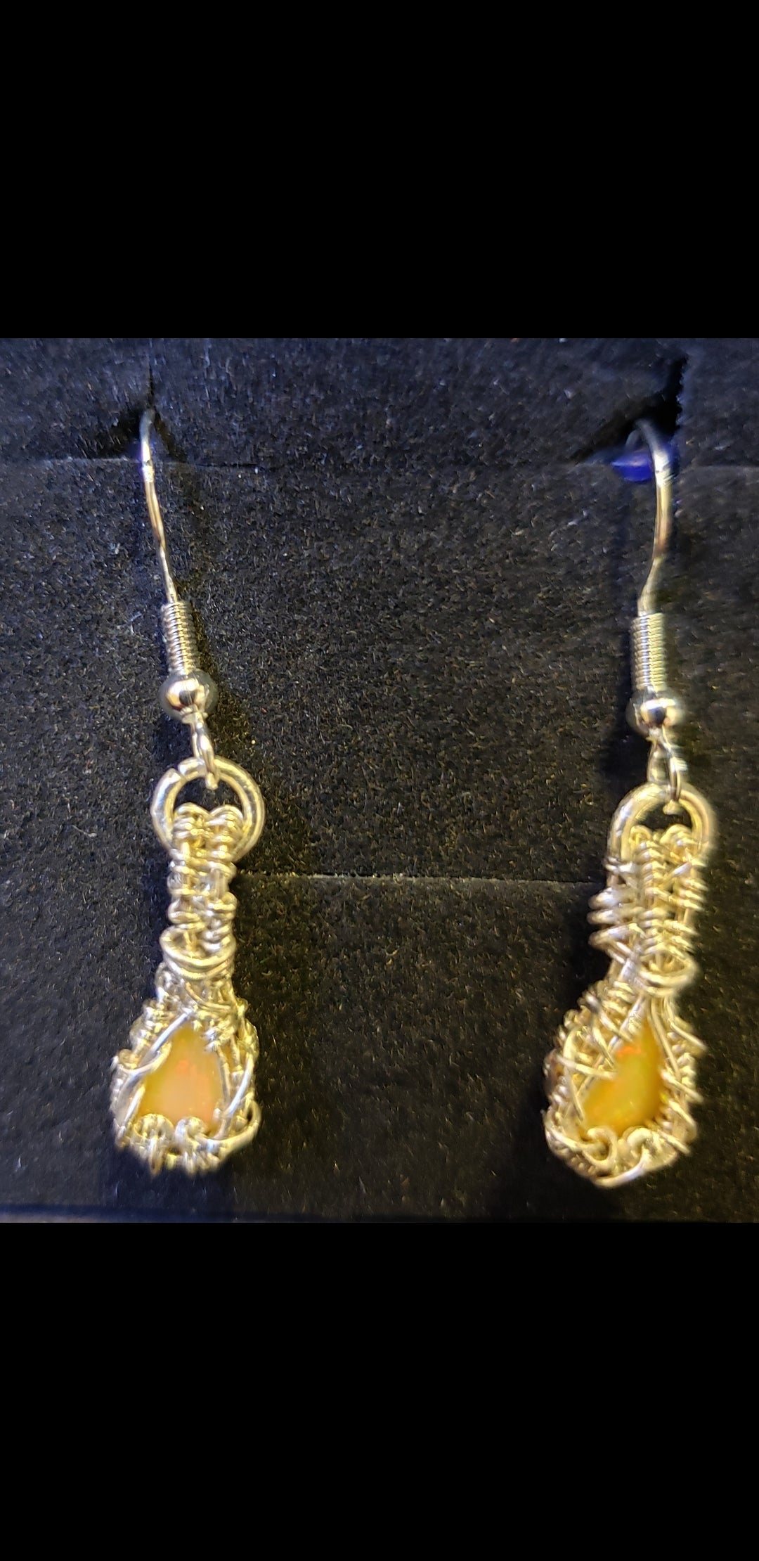 Pair of silver earrings on a black background