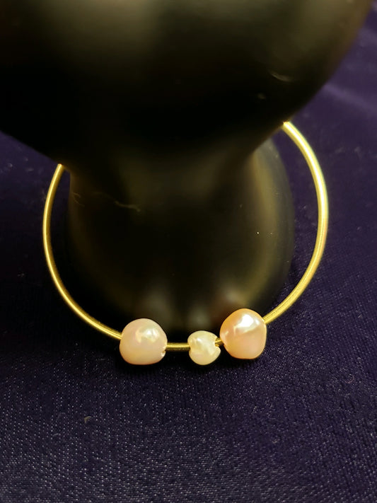Gold bracelet with pearls on a dark background