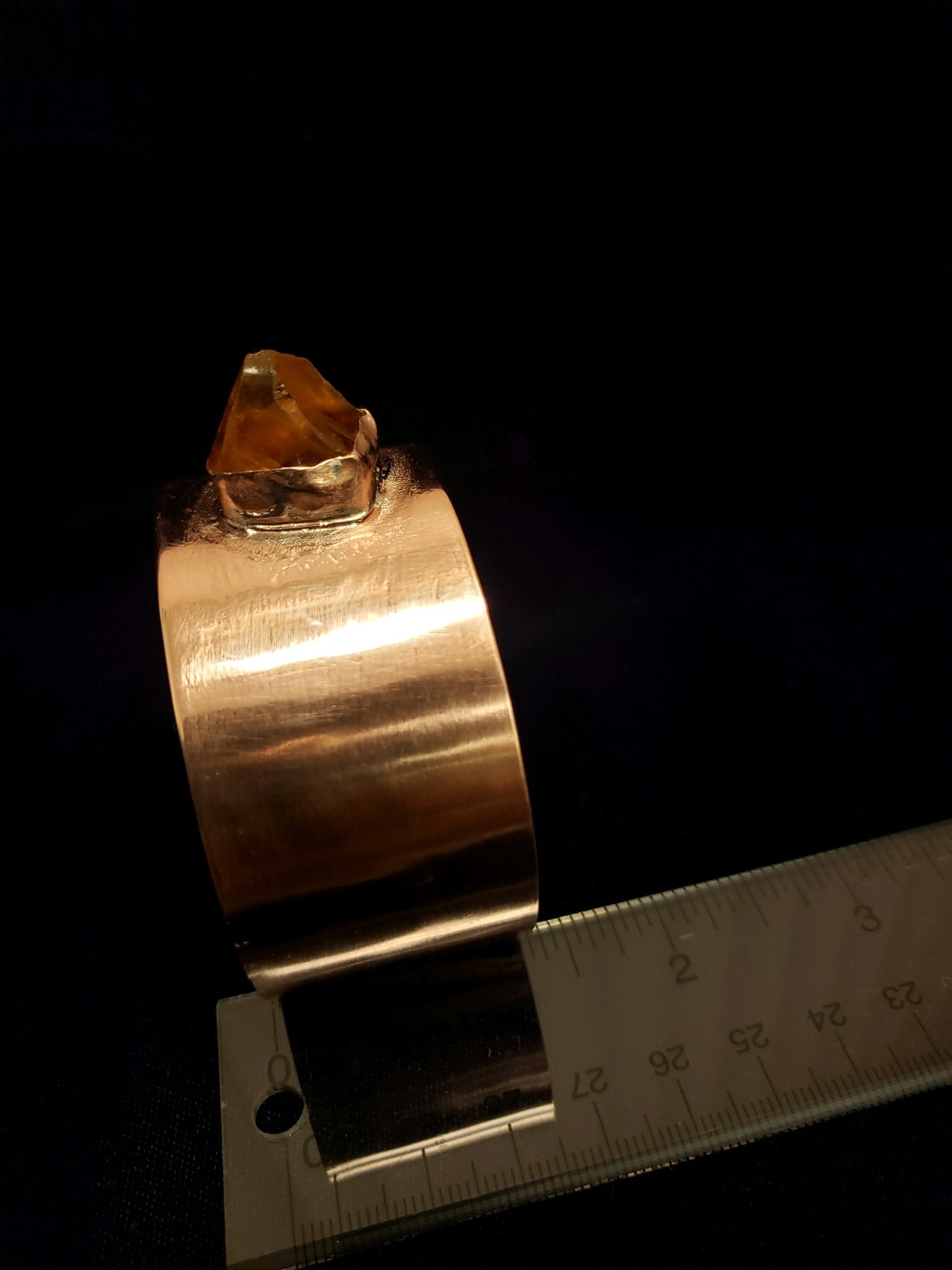 Gold ring with a large gemstone on a black background