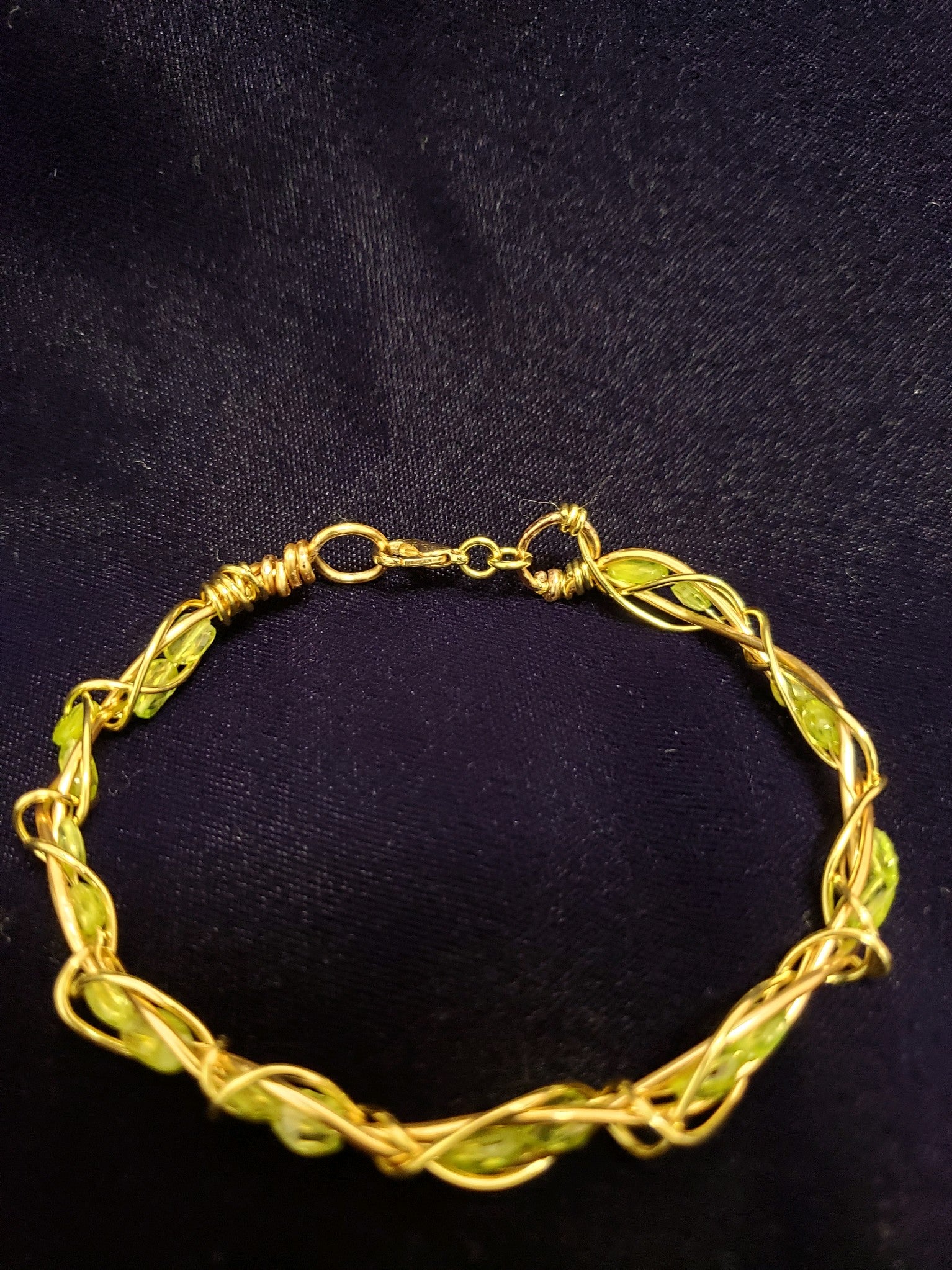  Gold and Peridot bracelet on a black background