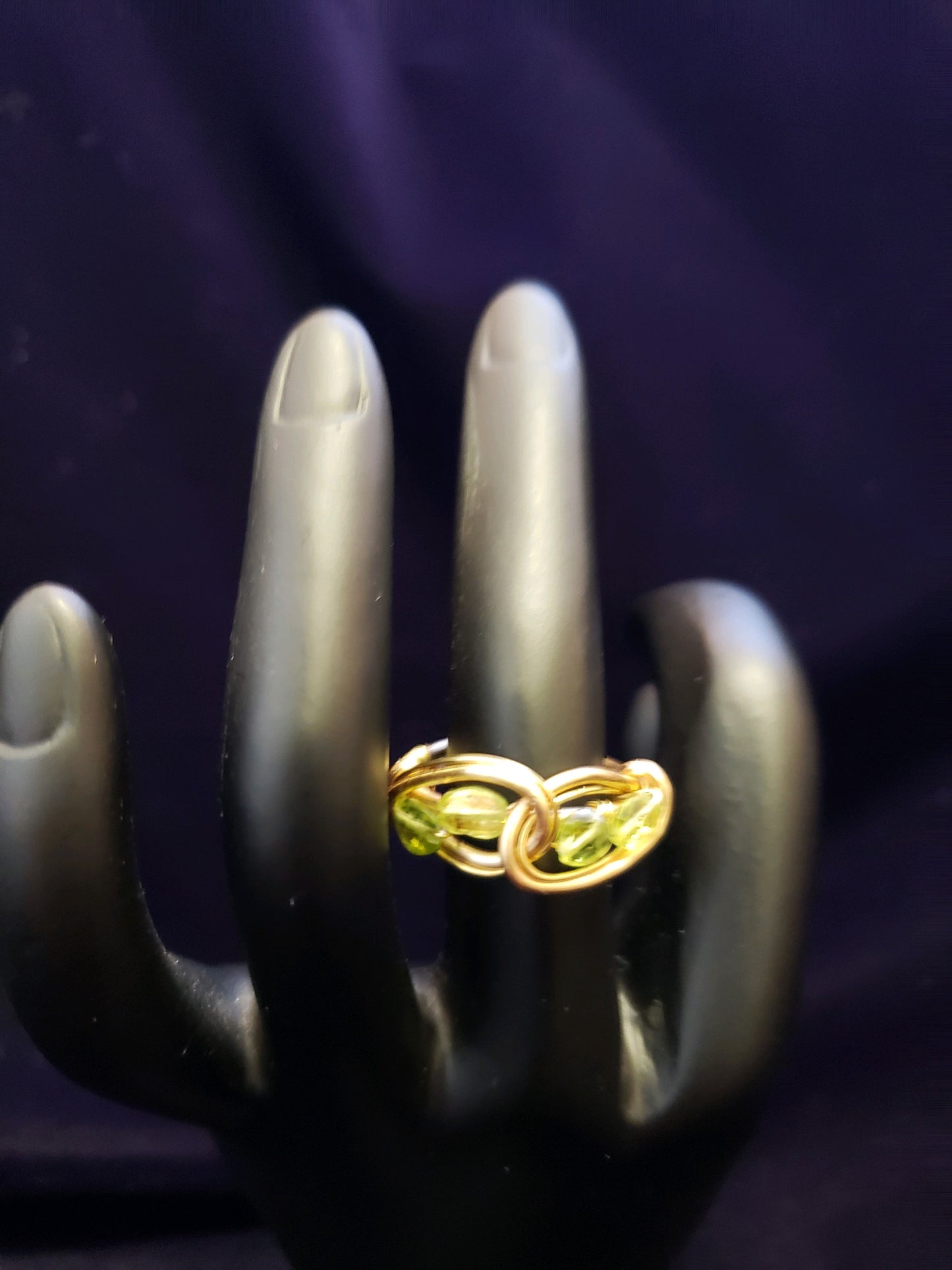 Gold ring on a hand with a dark background