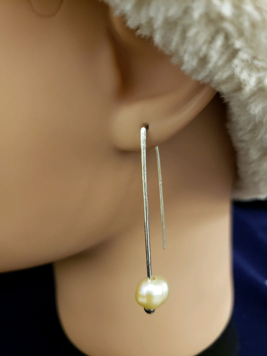 Pearl earring on a mannequin ear with a blurred background