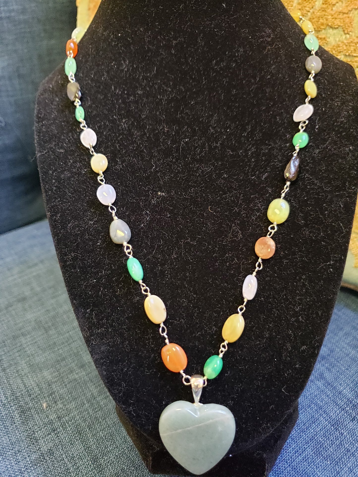Necklace with a heart-shaped pendant on a black stand
