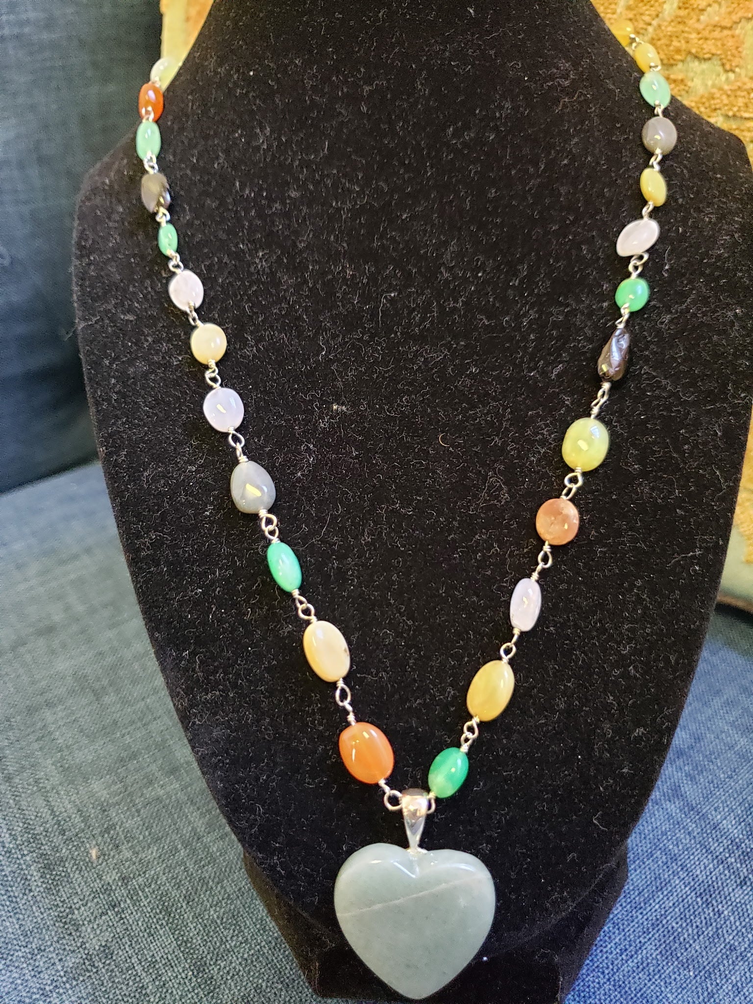 Necklace with a heart-shaped pendant on a black stand